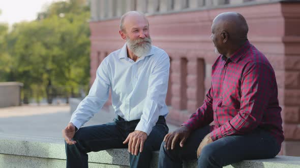 Diversity Smiling Colleagues or Friends Sitting Outdoors Have Pleasant Conversation alt