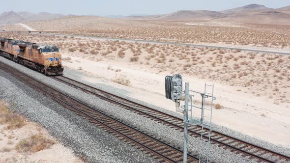 Freight Tain moving Aerial Footage. Freight train rides on the railroad in the desert. alt