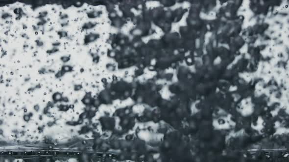 The Clear Sparkling Water is Poured Into a Transparent Glass Causing a Vortex of Oxygen Bubbles alt