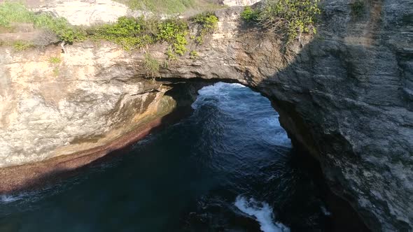 Aerial view of arch formation in the coast of Bali island, Indonesia. alt