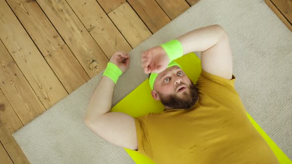 Fat Tired Man in Sportswear Lying on Mat and Breathing Resting After Exercises