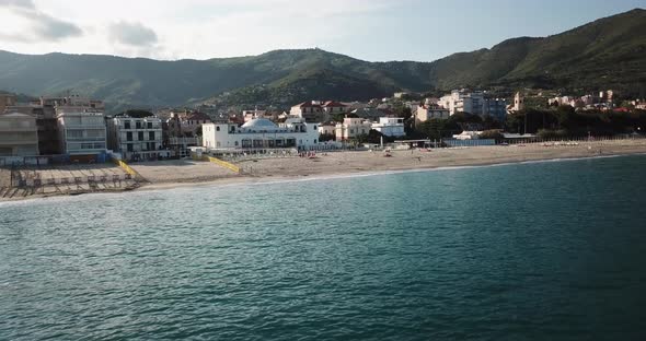 Drone view of the calm mediterranean surface near the shore during a sunset. Italy alt