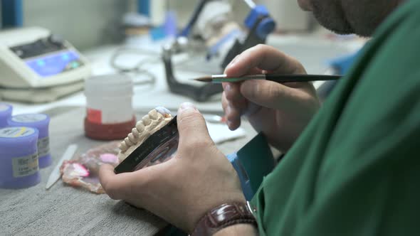 Technician applying porcelain to a dentition mold alt