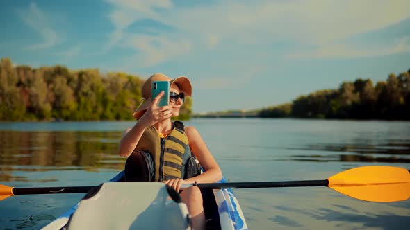 Girl Making Self Photo And Answer To Video Call. Holiday Vacation Trip On Weekend. Kayak Boat. alt