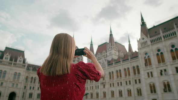 Woman Taking Picture Photo or Film of Budapest Parliament Building in Hungary