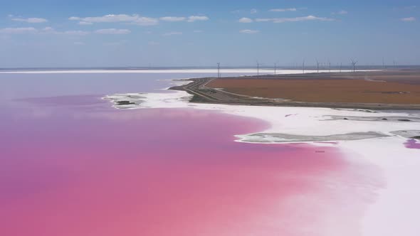 Flying over a pink salt lake. Salt production facilities saline evaporation pond fields 