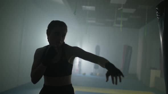 Blurred View of Woman Fighter Trains His Punches and Defense in the Boxing Gym Contour Lighting Slow alt