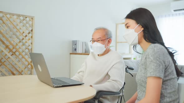 Asian senior male and daughter video call with doctor during pandemic. alt