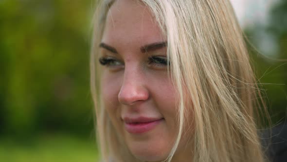 Attractive Woman Smiles for Camera Standing at Light Wind alt