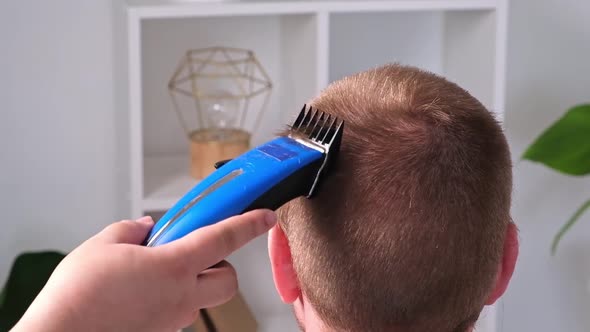 A Man Cuts His Hair with Clipper