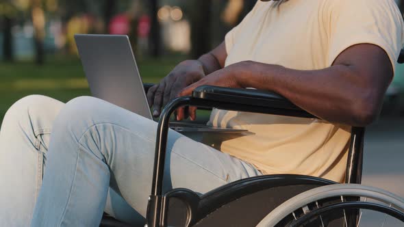 Closeup Side View of Adult Paralyzed African American Man Typing Text on Computer Keyboard alt