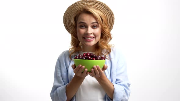 Cheerful Woman in Straw Summer Hat Smelling Cherry Bowl and Sharing It Selective Focus Harvest