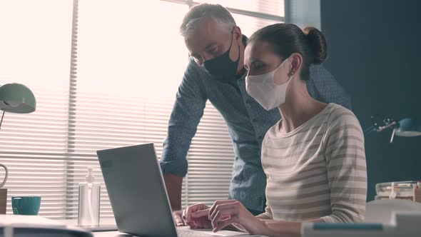 Business people working in the office and wearing face masks