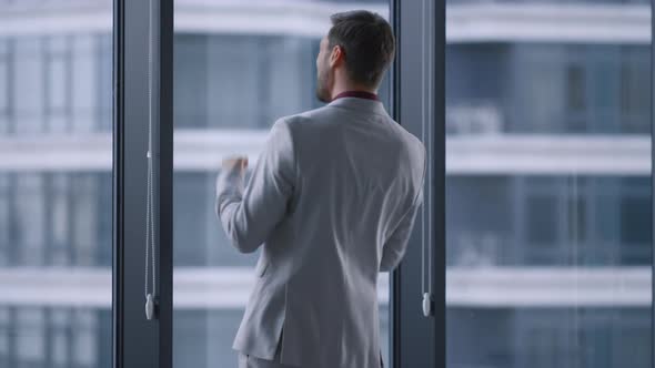 Overjoyed Man Celebrating Business Success Victory in Window Office Building alt