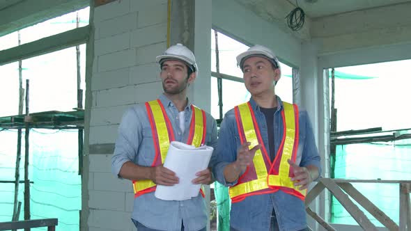 Young Asian engineers and caucasian engineer colleagues at site inspector and discuss together alt