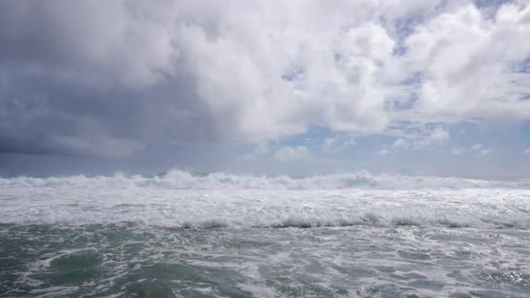 Ultra slow motion shot of strong foaming waves in turquoise waters on overcast day alt