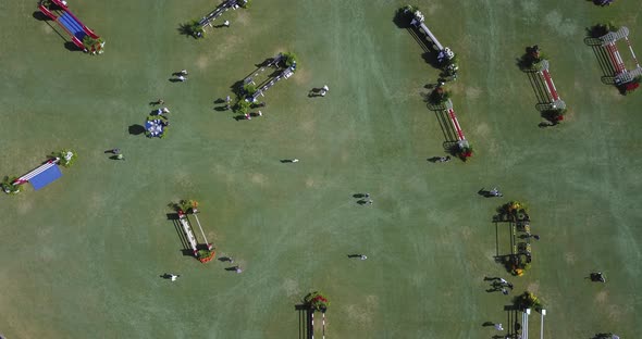 Top down aerial of riders doing a course walk at an equestrian park. alt
