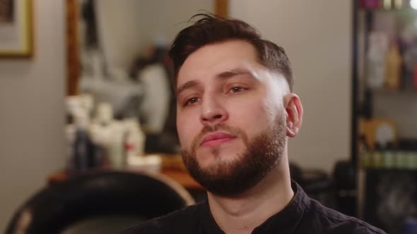 Handsome Young Happy Man Smiling After Haircut While Sitting in Chair in Barbershop alt