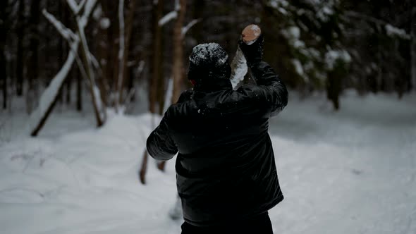 Sportsman is Training Alone in Nature Lifting Log in Forest in Winter Tensing Muscles of Arms alt