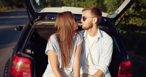 Couple Sitting in Car Trunk and Relaxing