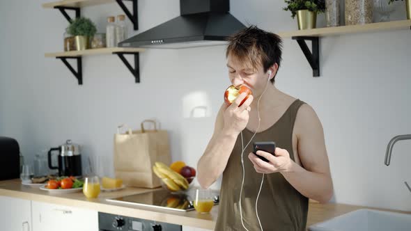 Happy Morning: Man 30 Has a Health Breakfast, Using Smartphone
