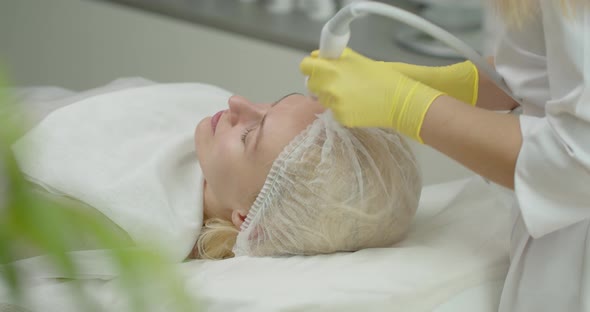 An Attractive Woman In A Beauty Clinic Receives A Procedure For Facial Skin.  alt