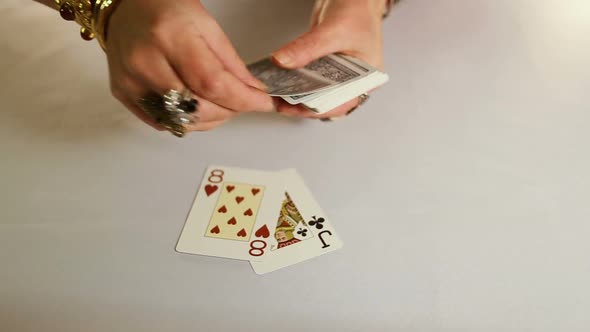 Female Hands With Gold Jewelery Lays Out Playing Cards.
