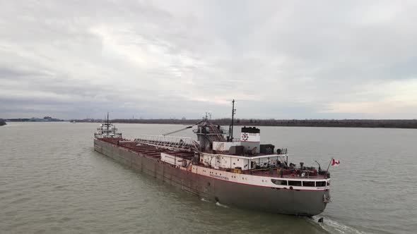 Old and rustic freighter with Canada flag on Detroit river, aerial view alt