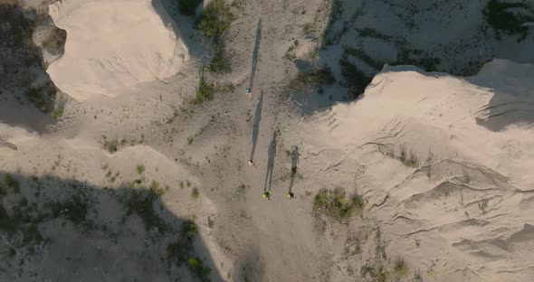 top aerial shot of people running in lime stone quarry with shadows, fetesti moldova during sunrise alt