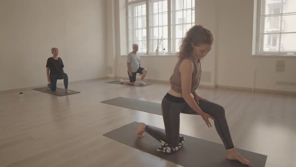 Yoga Instructor Showing Asana to Mature Couple alt