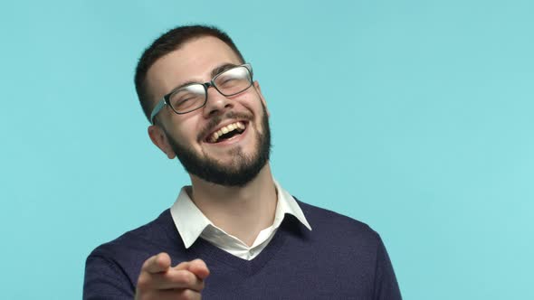 Cheerful Young Man with Beard and Glasses Office Worker Laughing and Pointing at Camera Checking Out