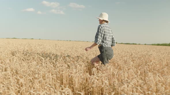 woman runing fun across the wheat field. agriculture dream concept. girl farmer hands to sides runs alt