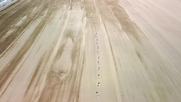 Top view of a woman walking t along beautiful sand beach. alt