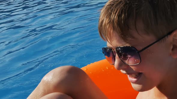 a Cute Cheerful Teenager Swims in the Pool Swims Sitting in a Swimming Orange Inflatable Circle