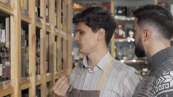 Male Wine Maker Helping His Customer While Working at His Wine Store alt