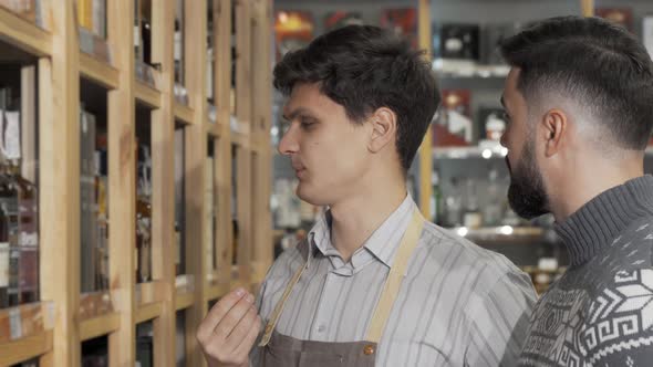 Male Wine Maker Helping His Customer While Working at His Wine Store