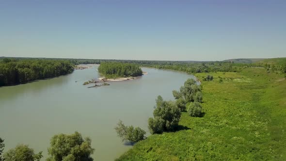Aerial: Flying Over the Mountain River. View of the Islands and the Forest alt