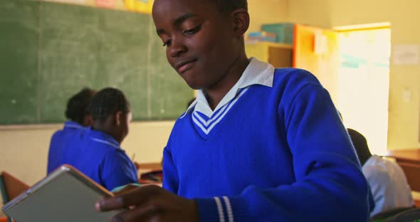 Schoolboy using tablet in a lesson at a township school alt