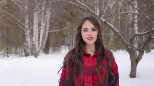 Charming Female with Long Hair Walking in Snowy Forest