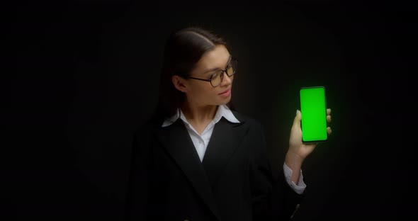 Business Lady in Glasses Shows Vertical Green Phone Screen for Copying alt