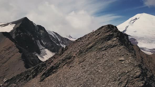 Aerial Flight of a Man in a Red Clothes Climbing Up Difficult Mountain Rock Slope