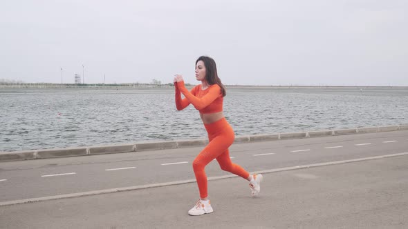 Fit girl doing exercises on the street. Sports lady goes in for sports outdoors. The concept of a he alt