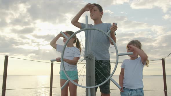 Children at the Helm of the Ship. Happy Childhood and Adventure Concept alt