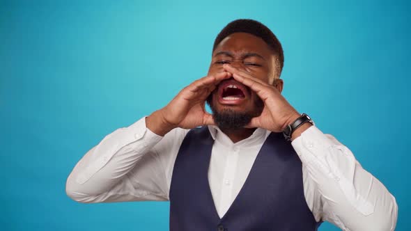 African American Man Put His Hands to His Face and Shout Against Blue Background alt