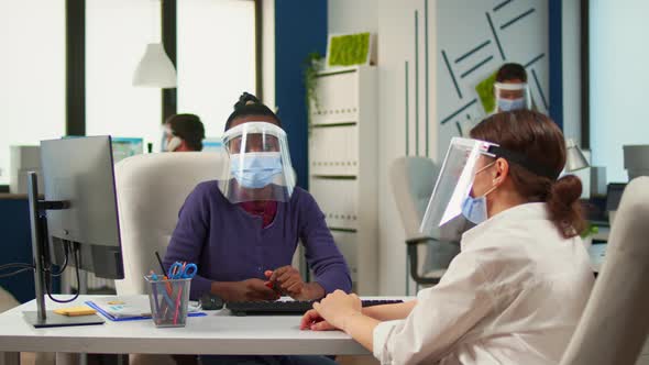 Multiethnic Partners Working in Office with New Normal Sitting at Desk alt