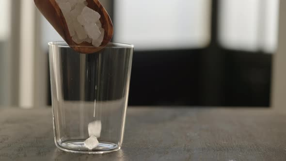 Slow Motion Fill Tumbler Glass with Crushed Ice on Oak Table with Copy Space alt