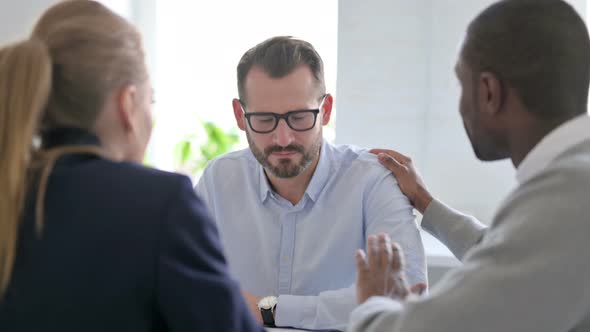 Male and Female Business Person Reassuring Upset Businessman alt