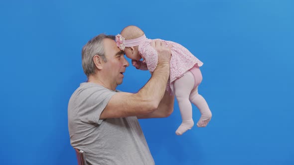 Funny Game and Laugh of Caucasian Old Man and Baby Girl in Domestic Comfort. Wrinkled Skin of alt