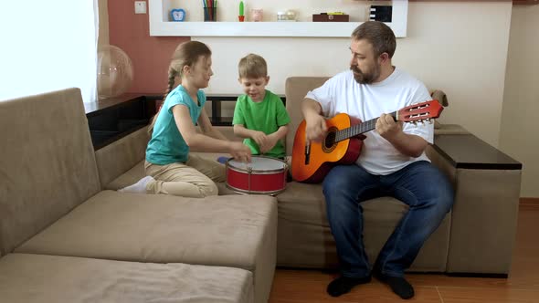 Dad and Children Play Guitar and Drum . Social Distancing and Self-isolation in Quarantine During