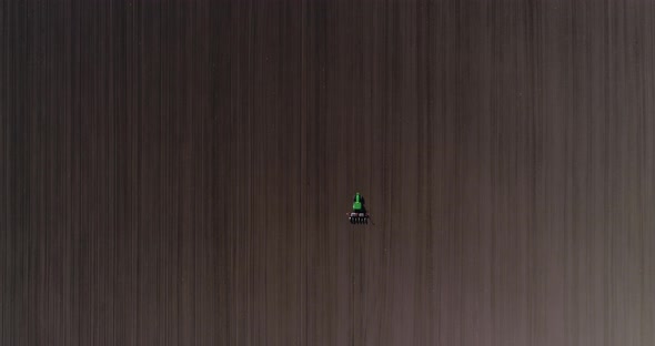 4k aerial view of tractor sowing wheat or sunflower in agriculture area alt